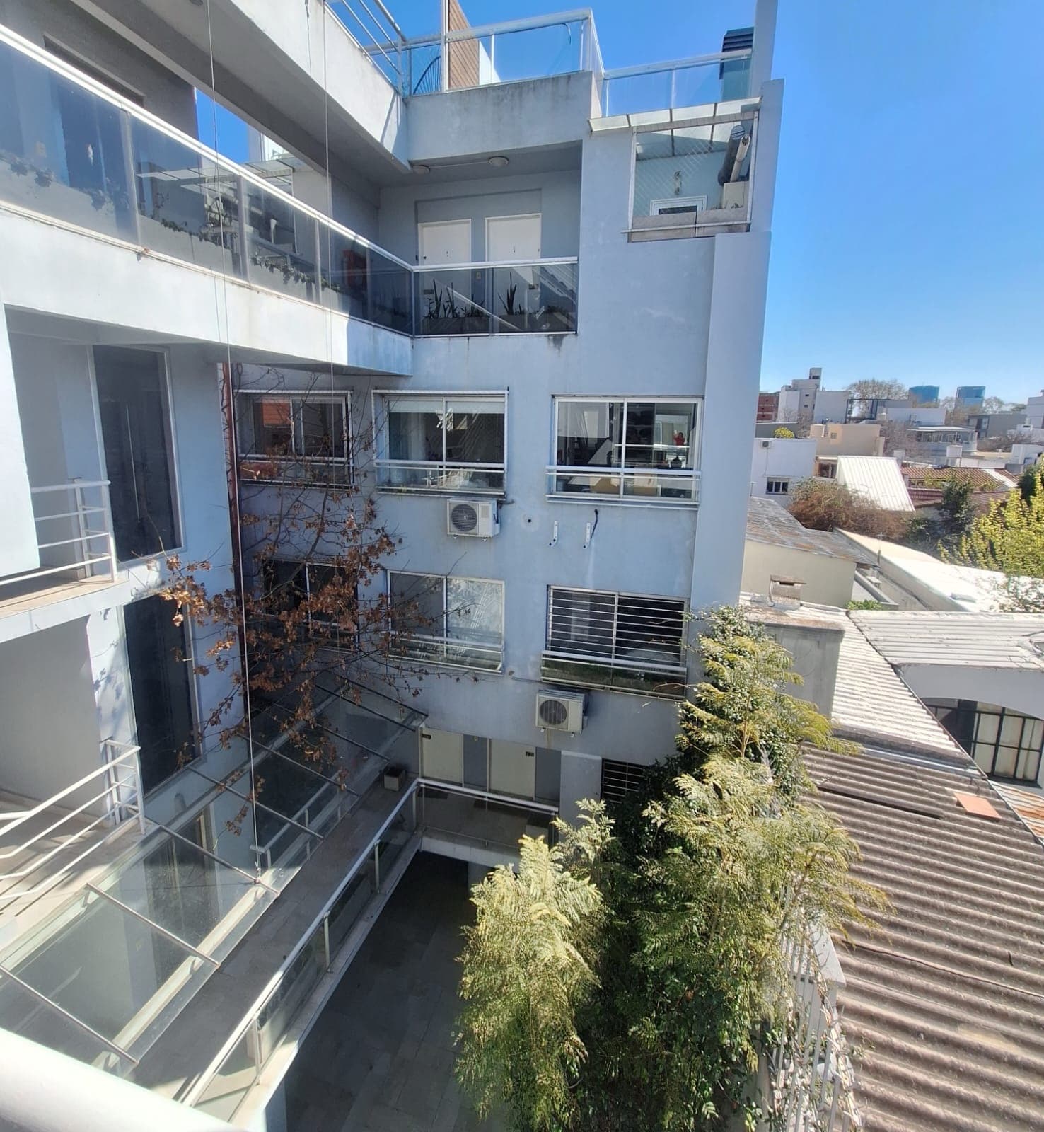 Interior del edificio con balcones, patios y árboles.