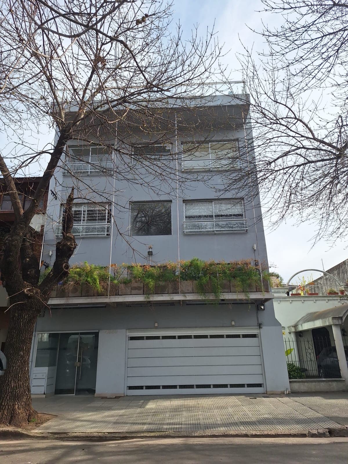 Fachada del edificio con garaje y balcones superiores.