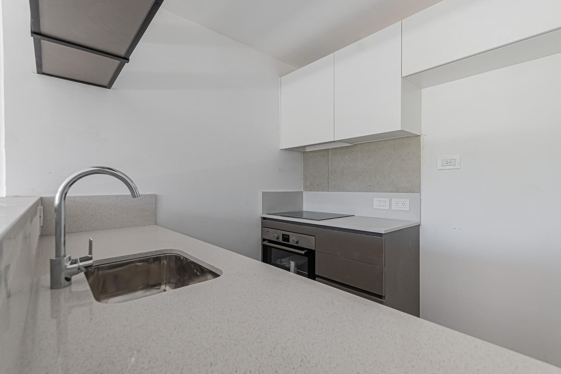 Cocina moderna con mesada, bacha, anafe y horno empotrado.