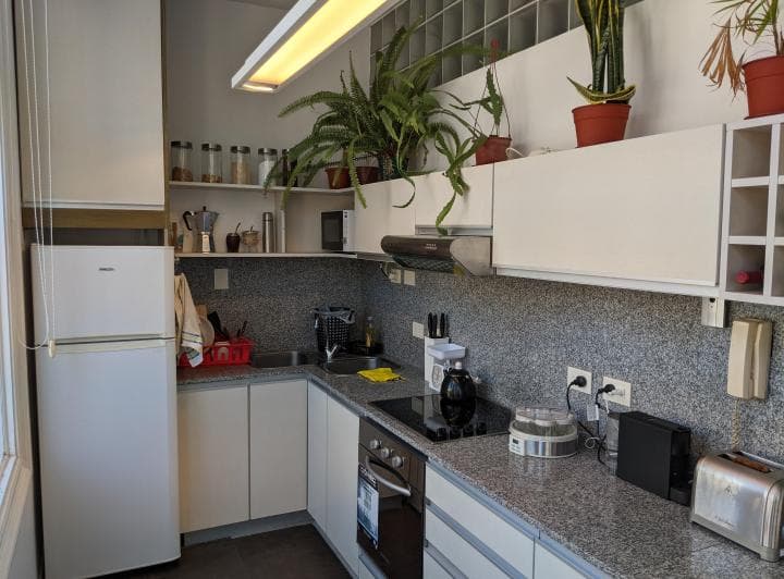 Cocina con mesada de granito, bacha, anafe y electrodomésticos varios.
