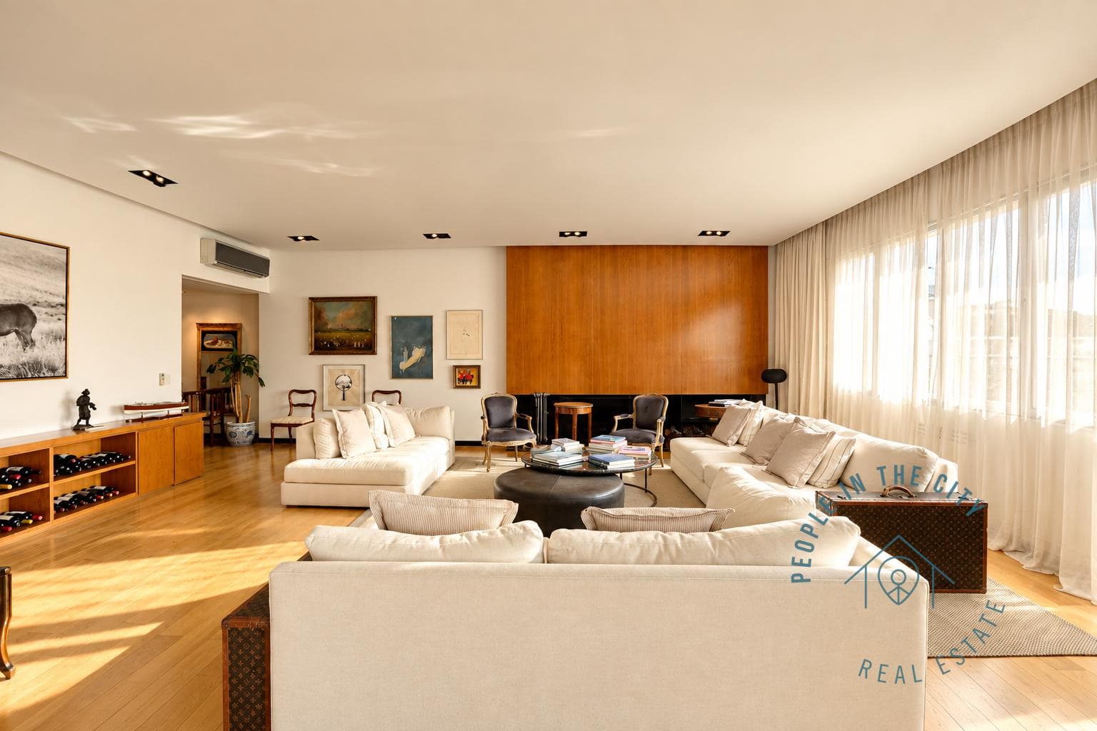 Living amplio con varios sillones y vista al comedor.