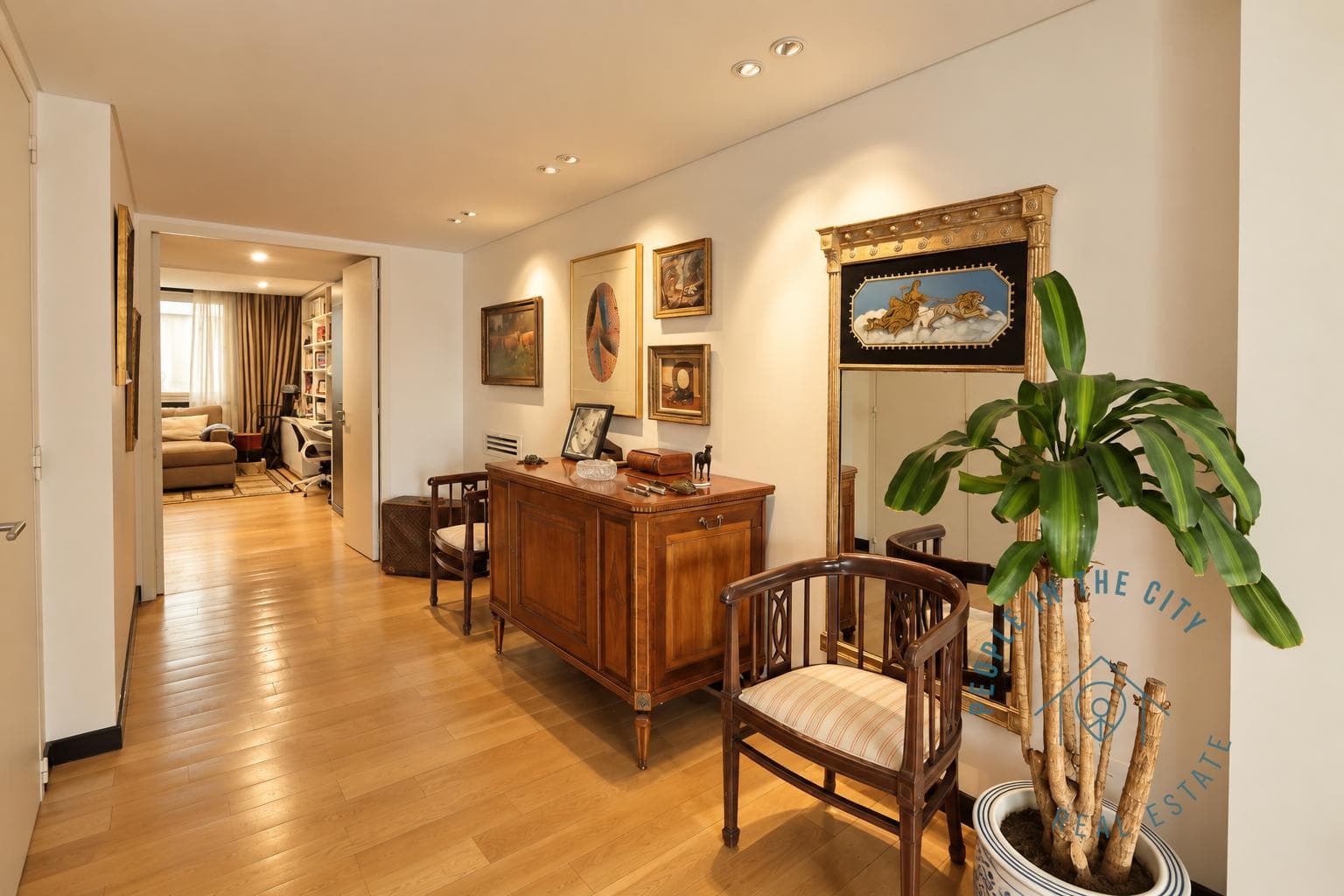 Pasillo con mueble de madera, espejo y plantas decorativas.