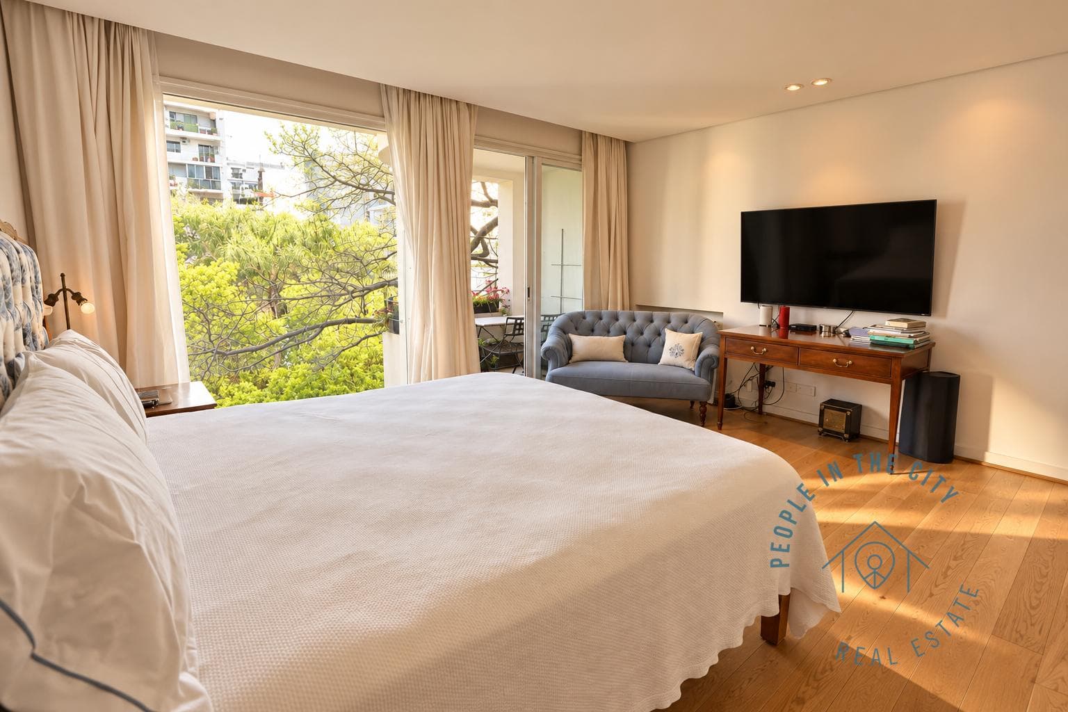 Dormitorio con cama, televisión y vista hacia el exterior.