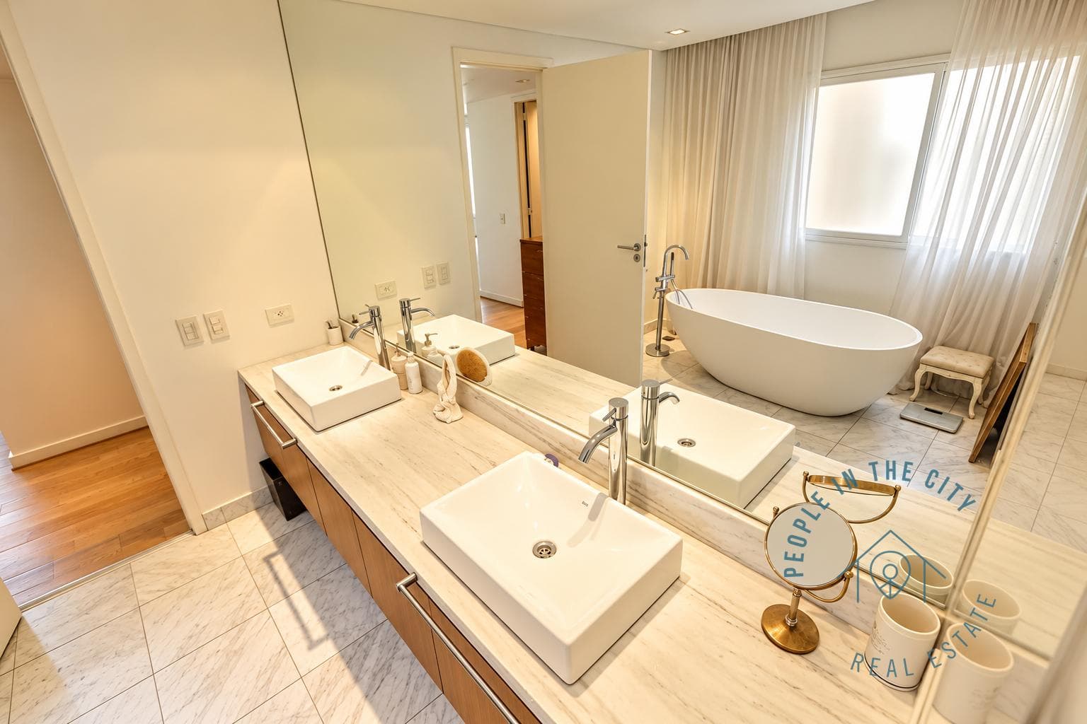 Baño principal con bañera exenta, doble bacha y amplio espejo.