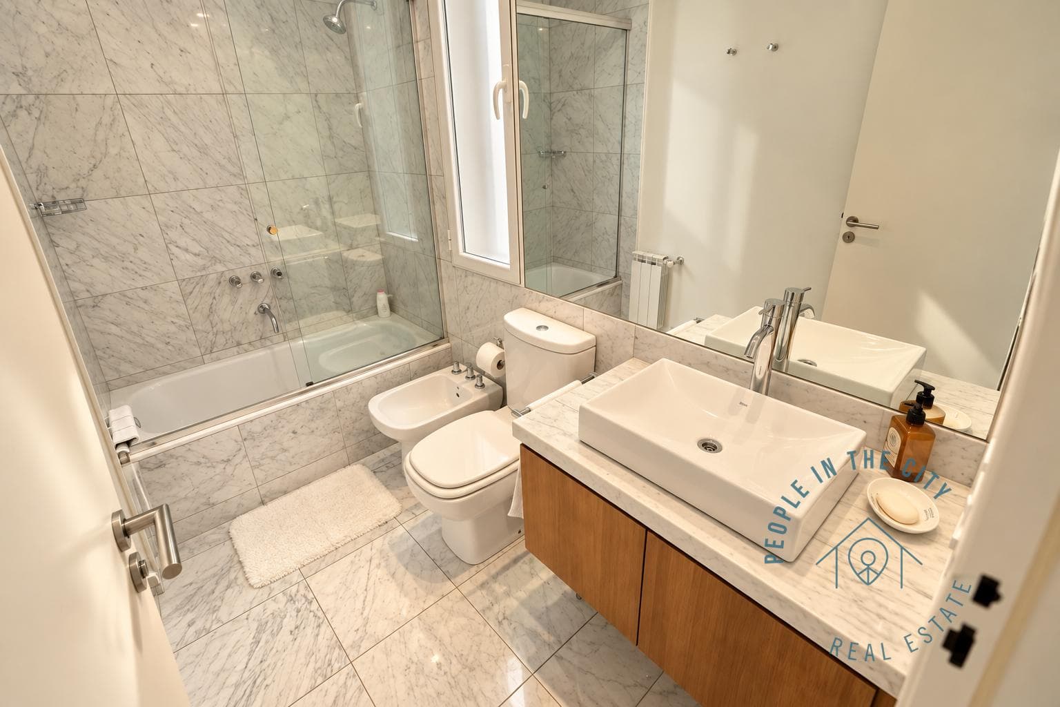 Baño con bañera con ducha, inodoro y bidet.