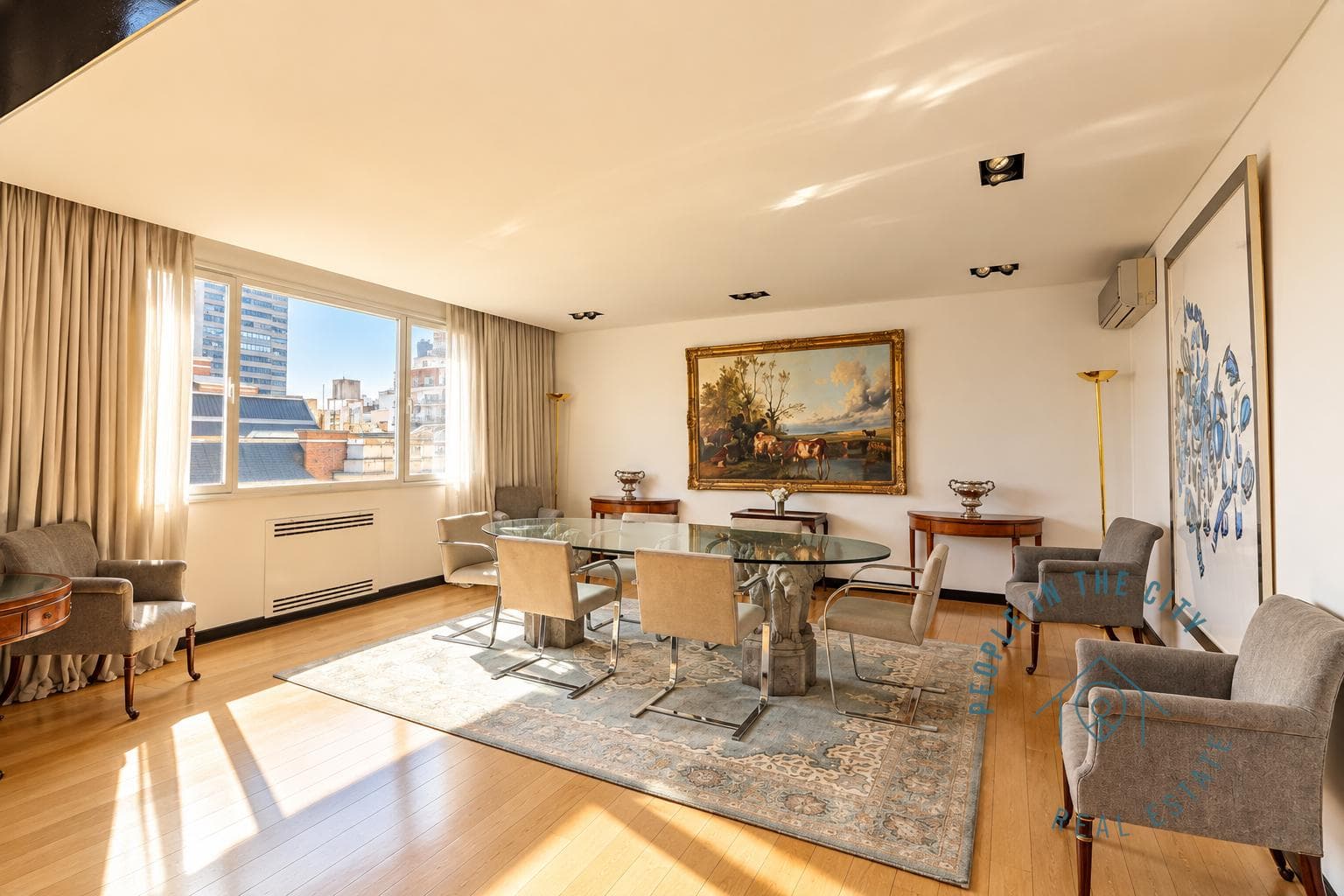 Comedor elegante con mesa de vidrio, sillas y ventana amplia.