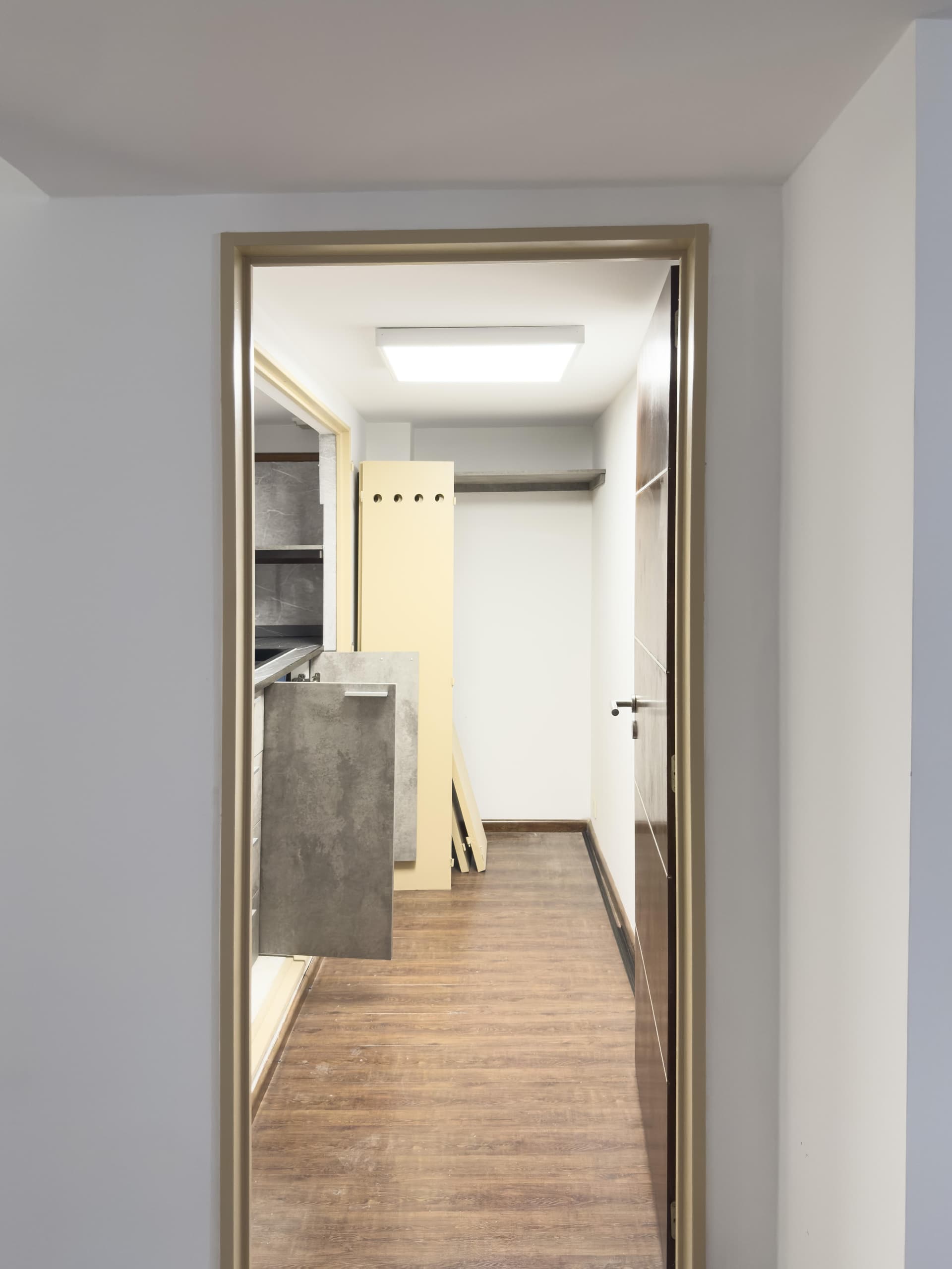 Cocina moderna con mesada, bacha, muebles, vista desde el pasillo.