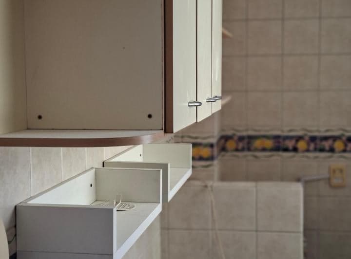 Detalle de los muebles superiores de cocina con azulejos decorados.