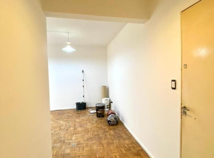 Living vacío con puerta de entrada y piso de parquet.
