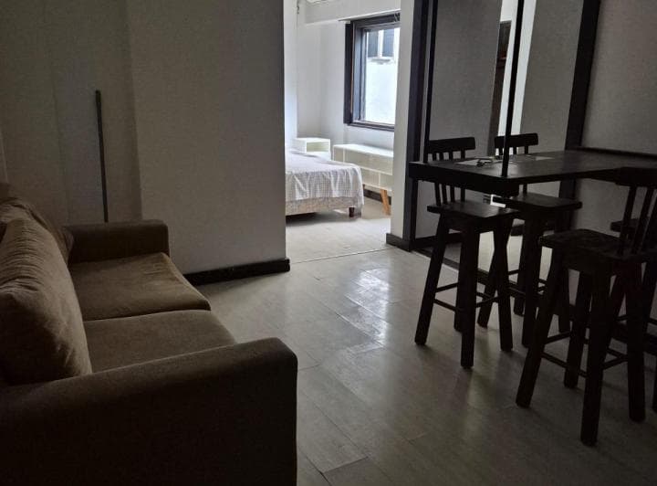 Living con sofá y barra, vista hacia el dormitorio al fondo.