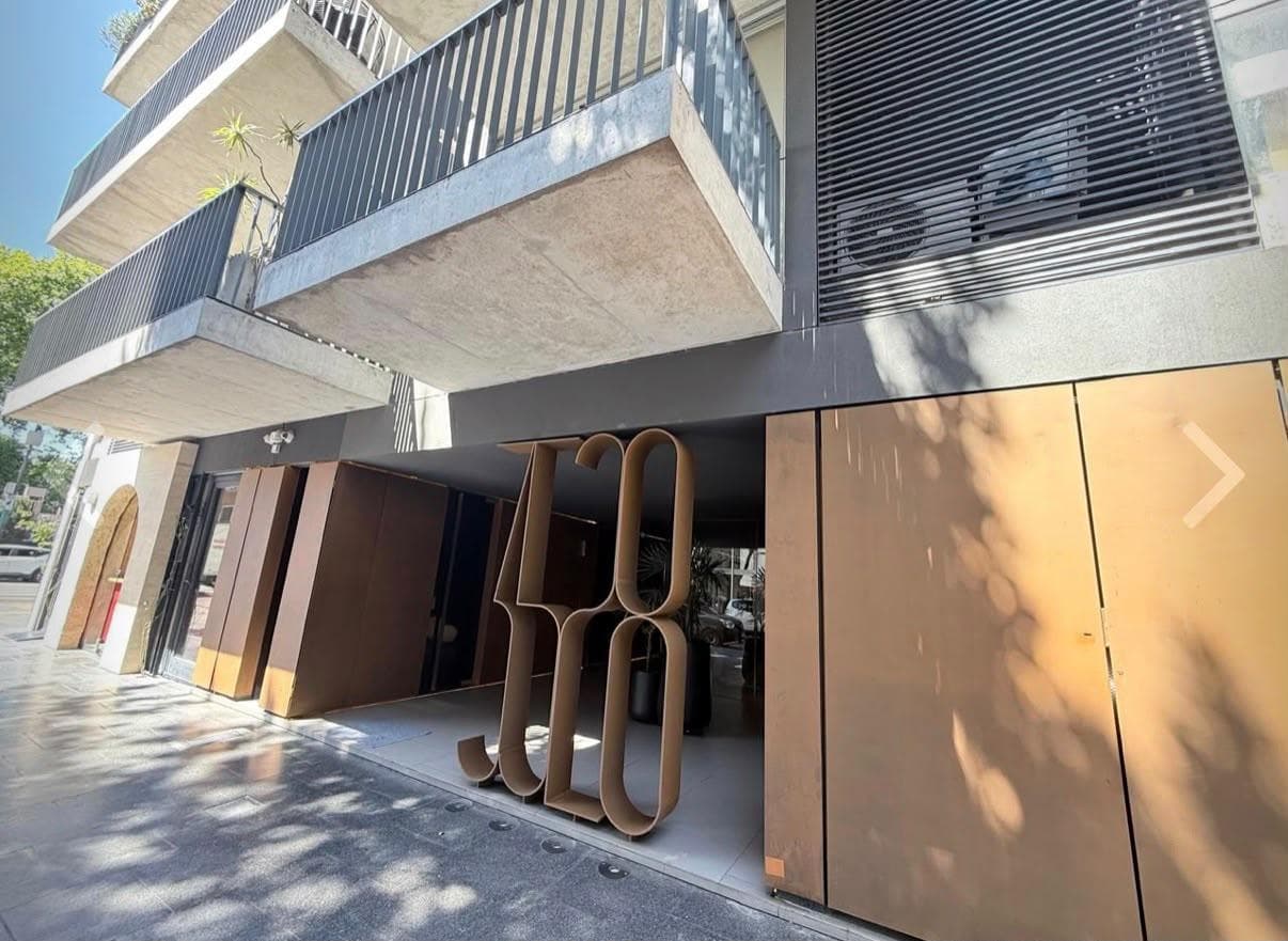 Parte baja de la fachada del edificio con entrada y balcones.