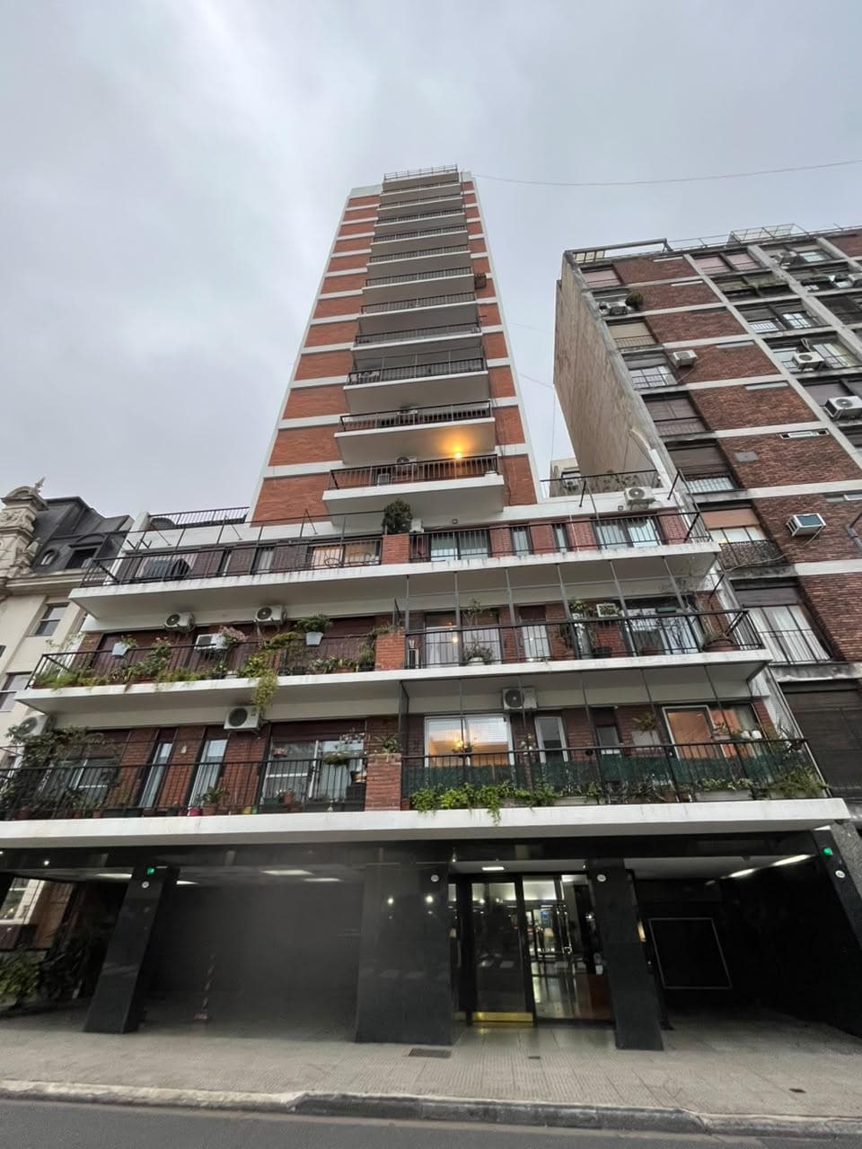 Edificio alto de ladrillo con balcones en la ciudad.