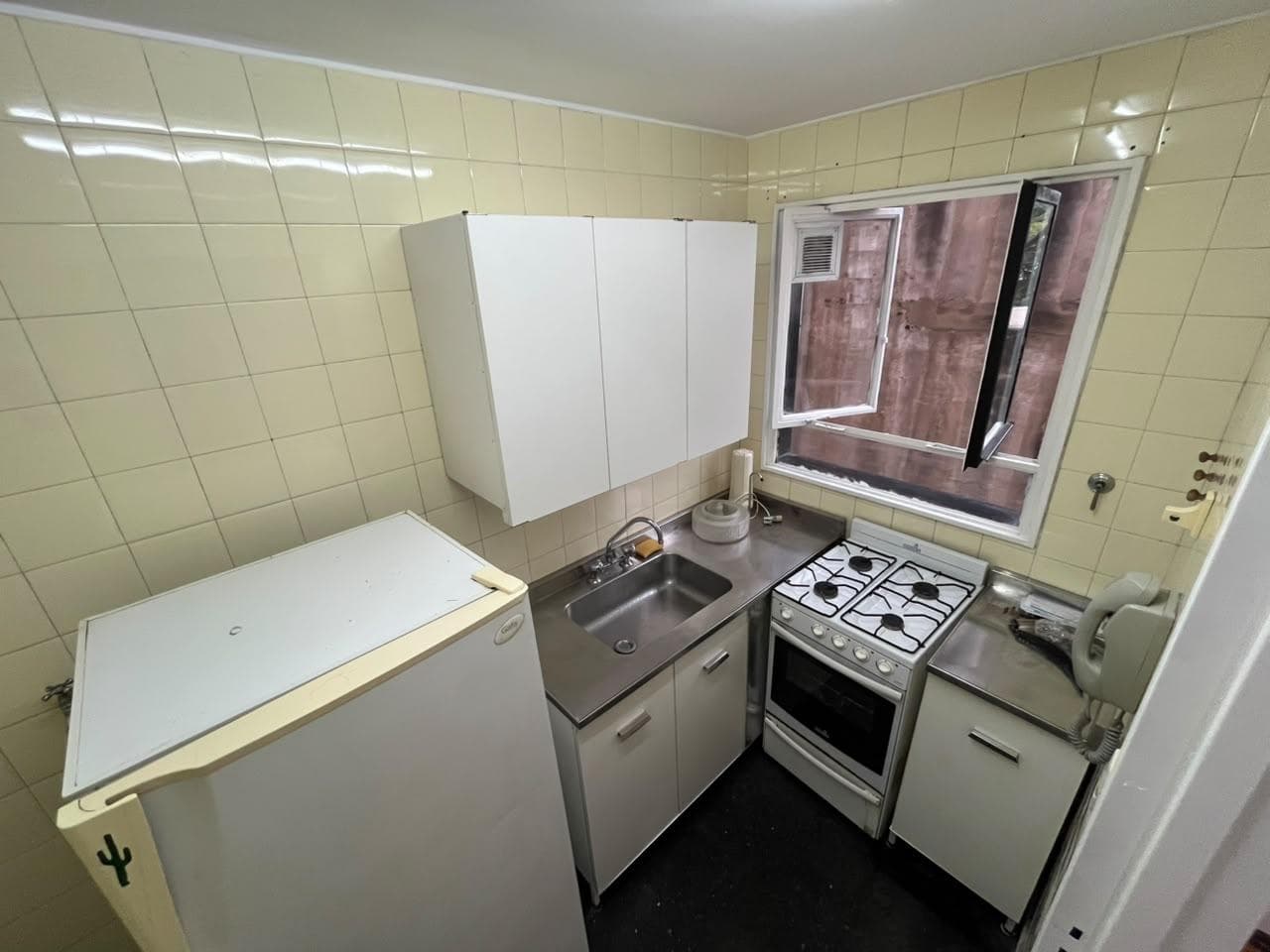 Cocina con heladera, mesada, bacha, anafe, horno y alacenas.