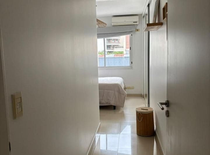 Dormitorio con cama doble, aire acondicionado y placard, visto desde el pasillo.