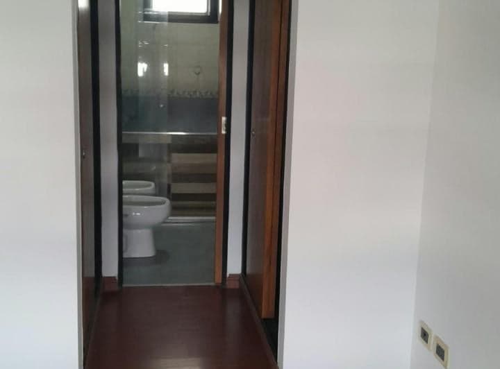 Pasillo con vista parcial a un baño con inodoro y bidet.