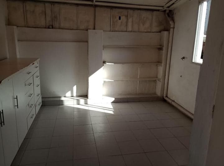 Cocina con mesada, estantes y ventana, sin electrodomésticos