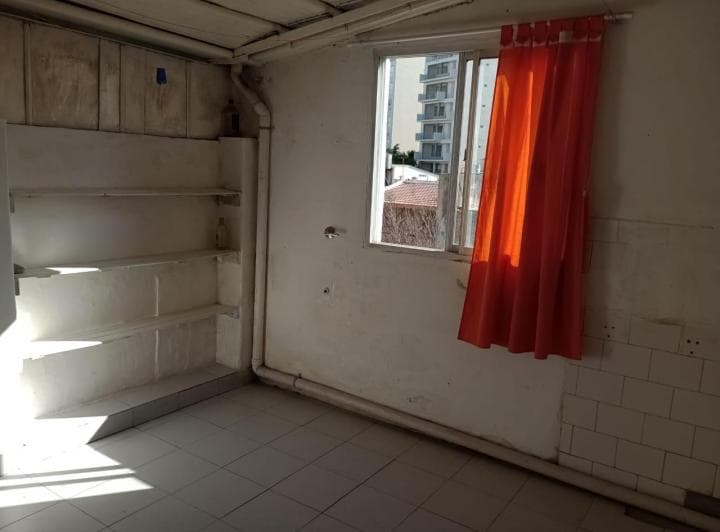 Cocina con estantes vacíos y ventana con cortina naranja