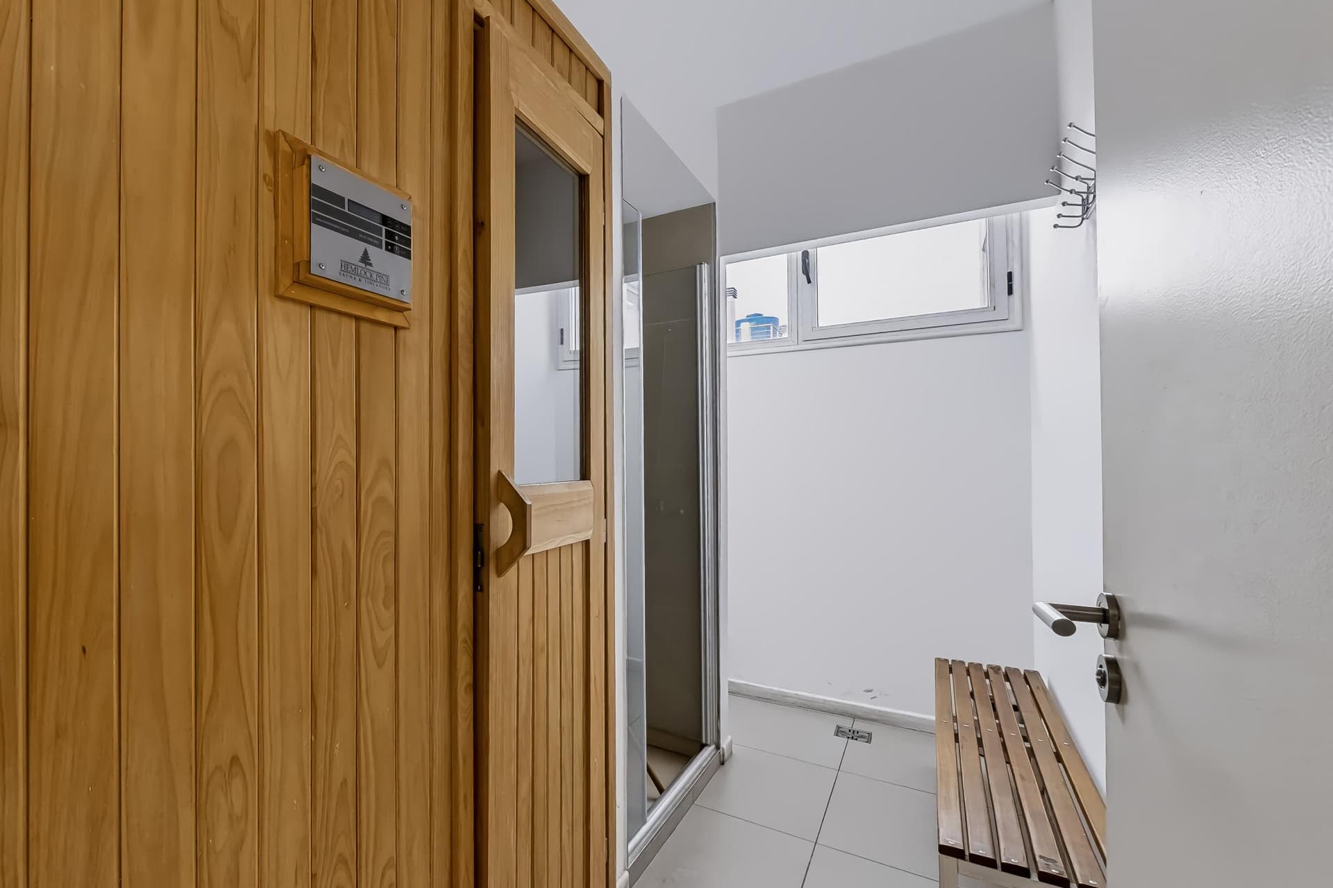 Sauna de madera, banco de madera y área de duchas.