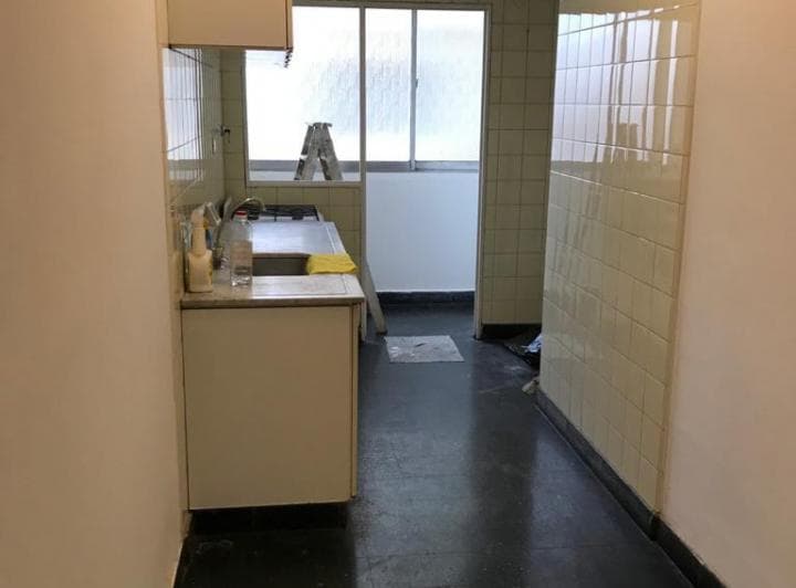 Cocina con mesada, bacha, anafe, azulejos blancos y ventana al fondo.