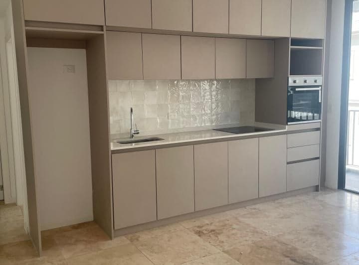 Cocina integrada con horno, anafe, bacha, alacenas color madera y bajo mesada.