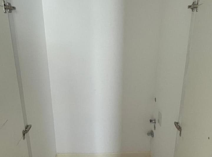 Lavadero con tomas para lavarropas y canillas de ducha en la pared.
