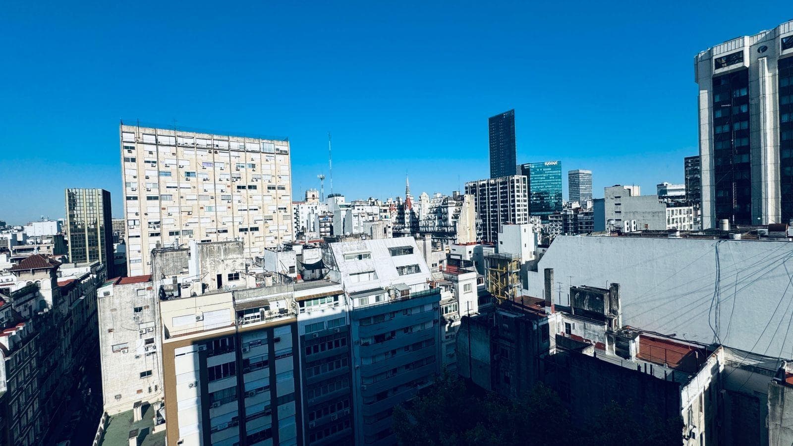 Vista: panorámica de la ciudad con edificios y cielo azul brillante.